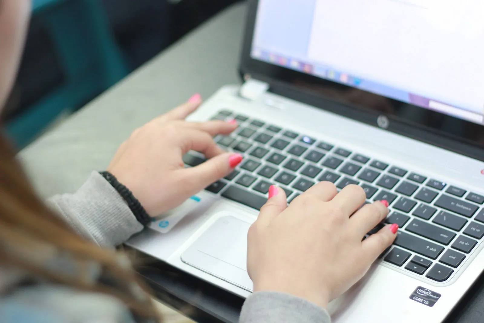 Krupni plan ruku koje kucaju na tastaturi laptopa